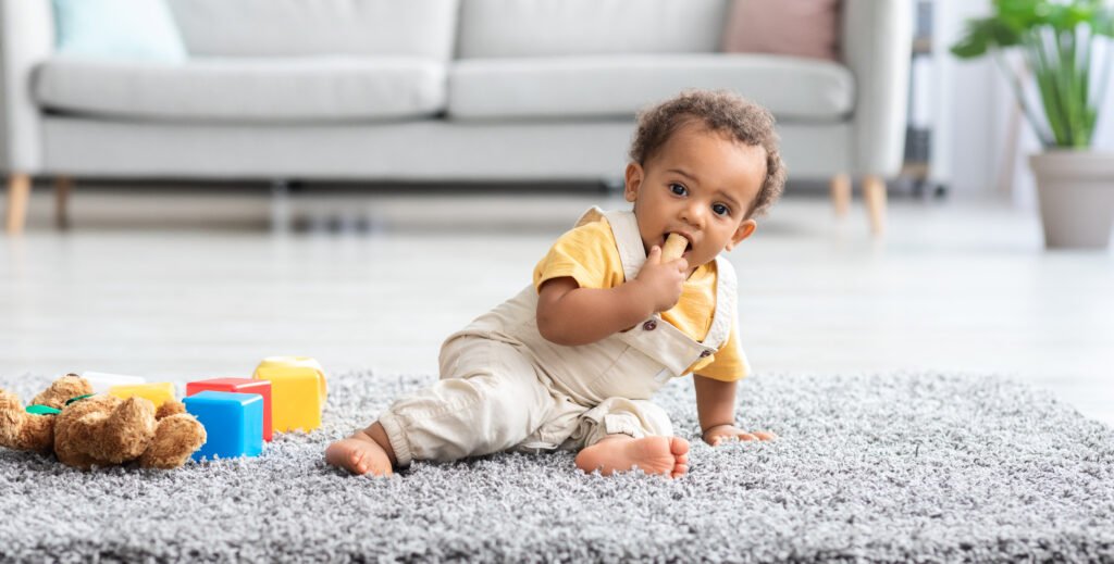 Baby Safety. Adorable Little Black Boy Biting Wine Cork Found On Floor