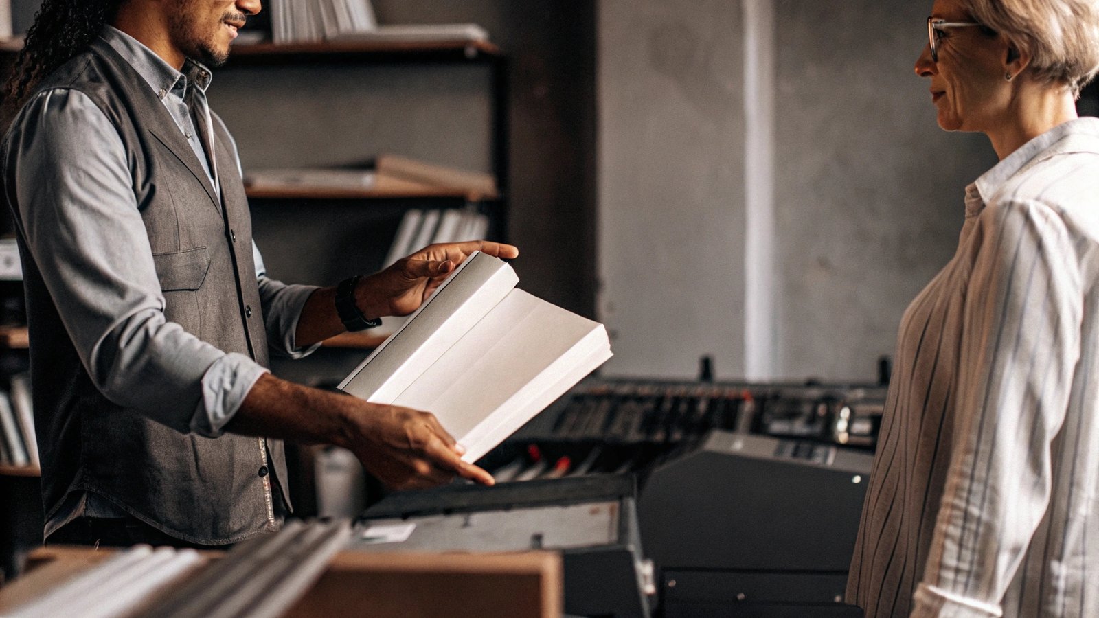 A client happily reviewing a high-quality printed cookbook sample.