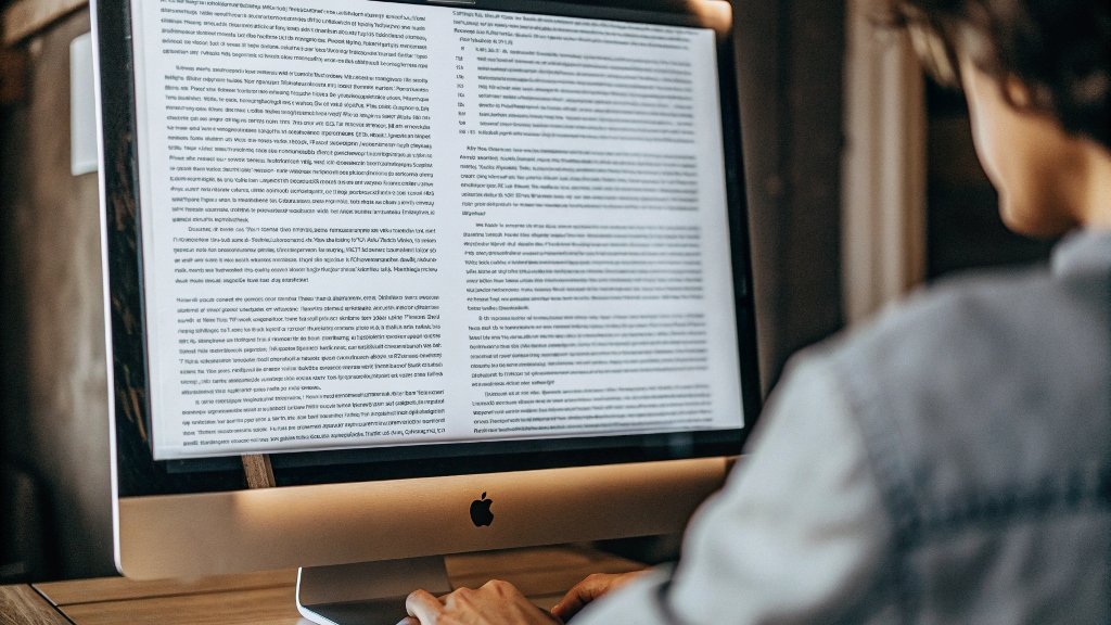 A person reviewing a book manuscript on a computer screen.